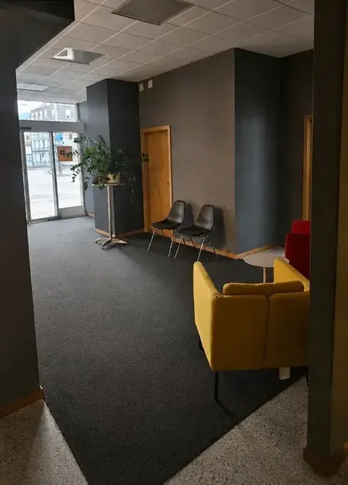Espace d’accueil de bureaux nettoyé, fauteuil jaune, sol dégagé